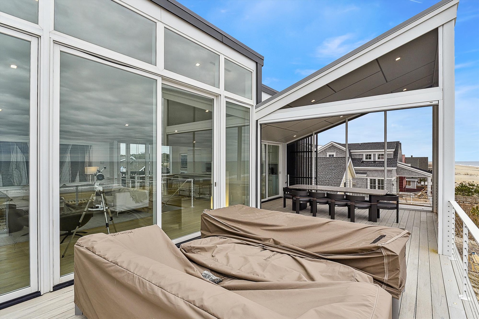 This spacious beachside deck offers stunning coastal views and comfortable lounge seating, perfect for soaking up the sun or unwinding with ocean breezes after a day at the beach.