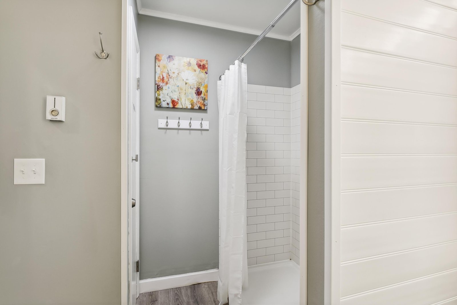 Step into your private bathroom featuring a clean, modern design with a refreshing walk-in shower. The crisp white subway tile and calming neutral tones create your perfect morning retreat.