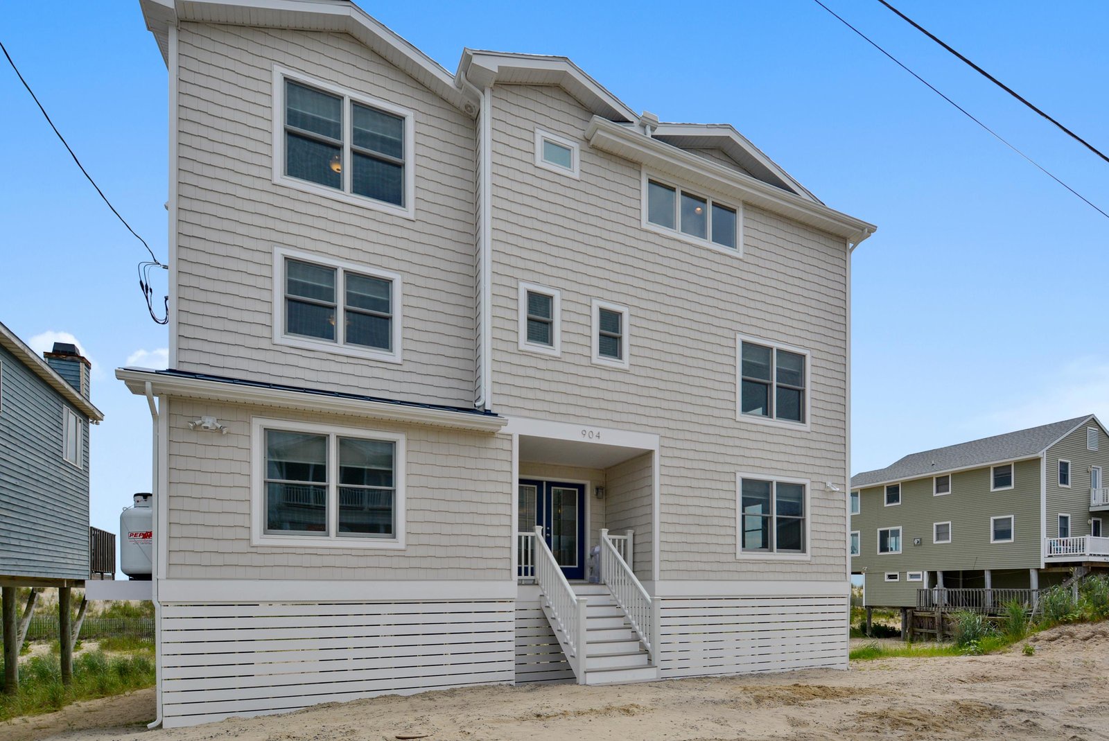 A spacious beachside retreat with modern coastal architecture, situated in a quiet residential area just steps from the shore.