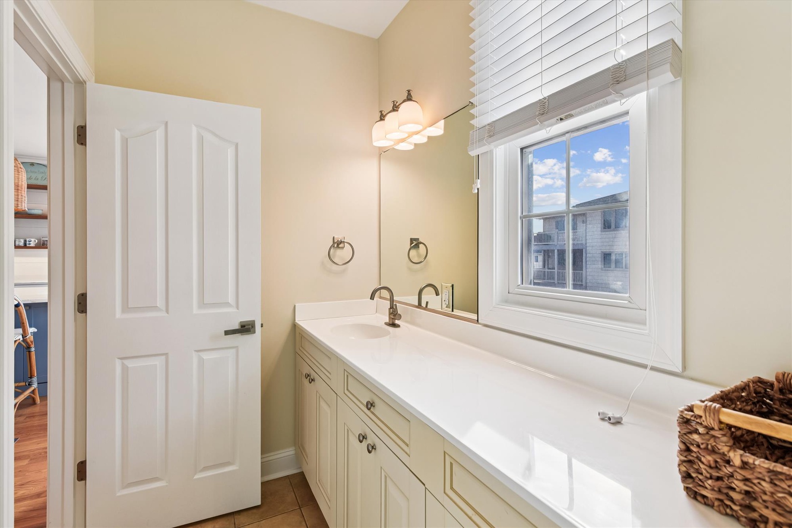 Step into your bright, clean bathroom with dual sinks, plenty of counter space, and soft natural light streaming through the window—perfect for morning routines.