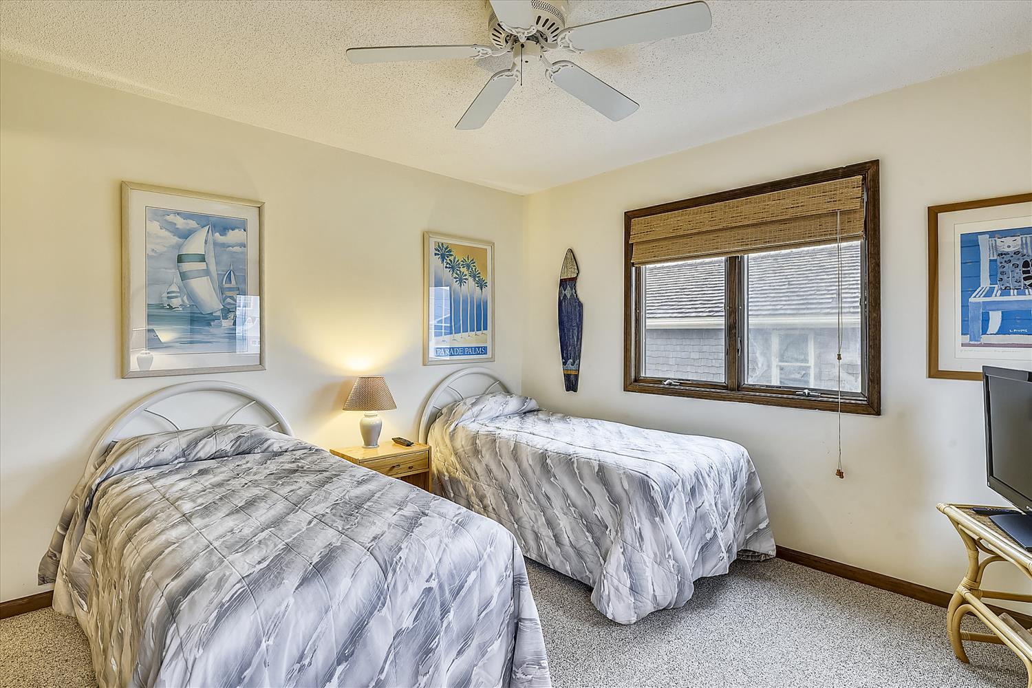 Your bright twin bedroom features comfortable beds, nautical artwork, and a ceiling fan to keep you cool during your stay.