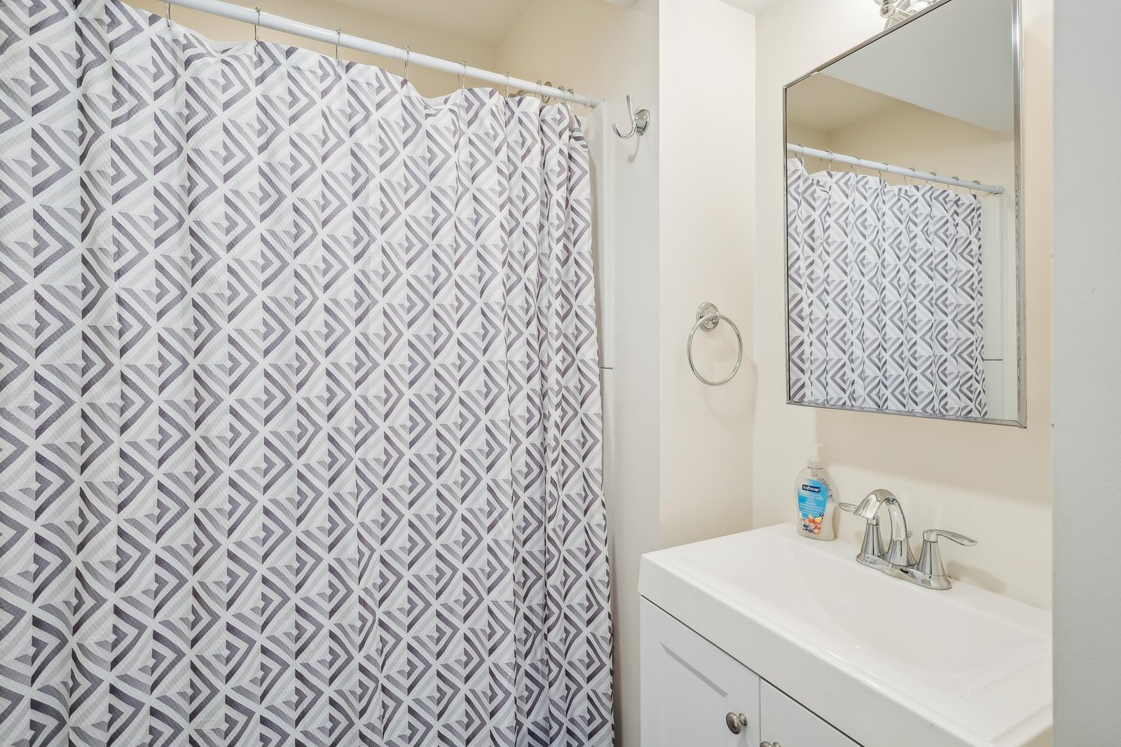 Your private bathroom features a fresh, clean design with a modern vanity and stylish geometric shower curtain. Everything you need for a comfortable refresh after a day of adventures.