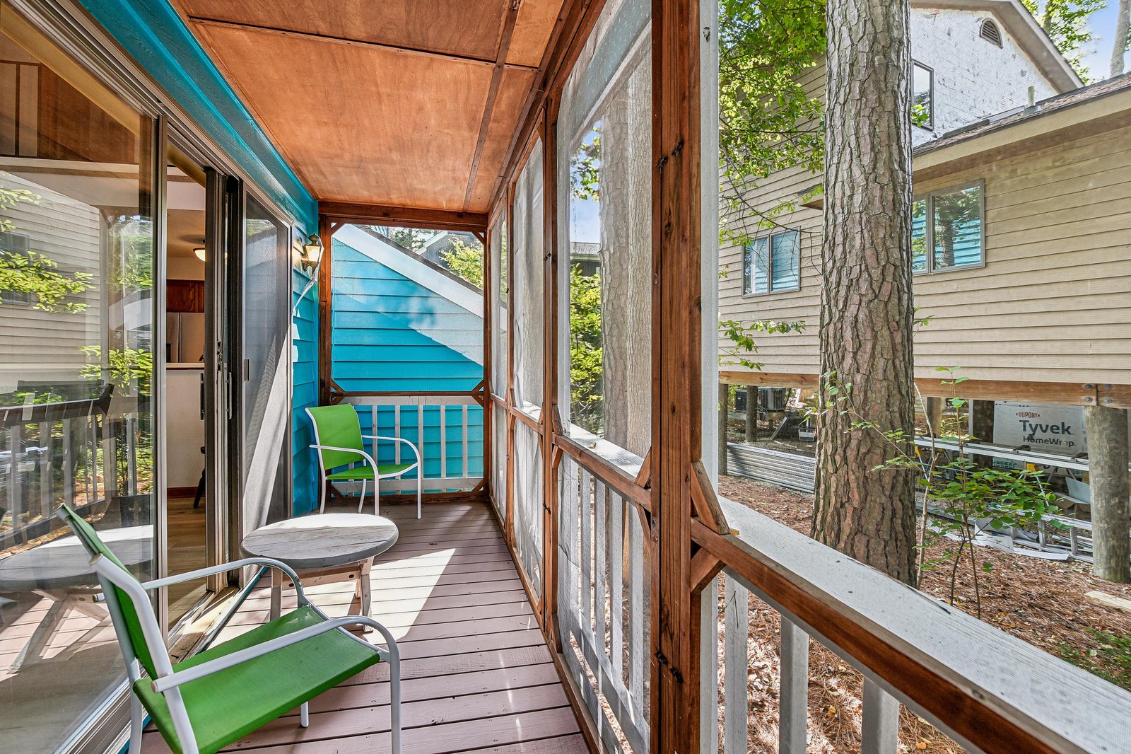 Relax on your screened balcony with morning coffee, surrounded by tall pines and leafy shade. This quiet outdoor nook is your peaceful escape between the trees.