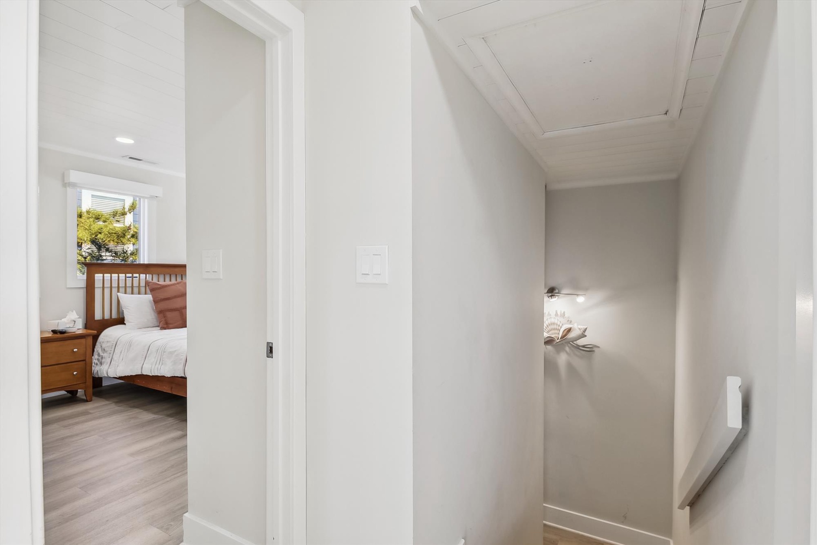 Bright hallway connects your bedroom spaces, with crisp white walls and modern lighting creating a clean, peaceful flow throughout your stay.