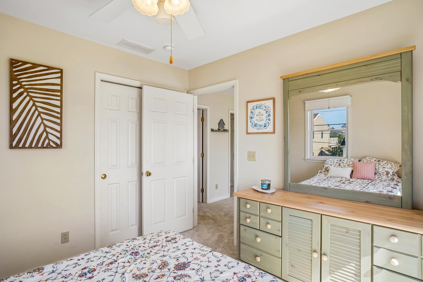 Drift off in your cozy bedroom with two beds, charming coastal decor, and soft natural light streaming through the window—a perfect retreat for restful nights.