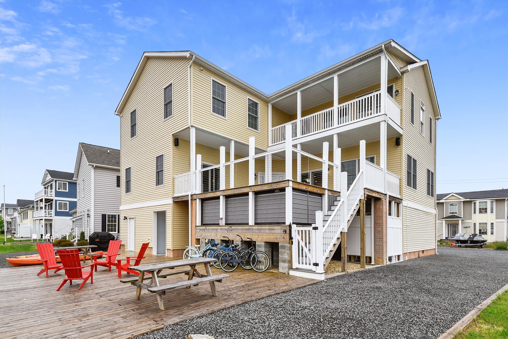 Bright coastal architecture with spacious covered balconies, outdoor seating, and bikes ready for exploring—your perfect beach retreat with room for the whole crew.