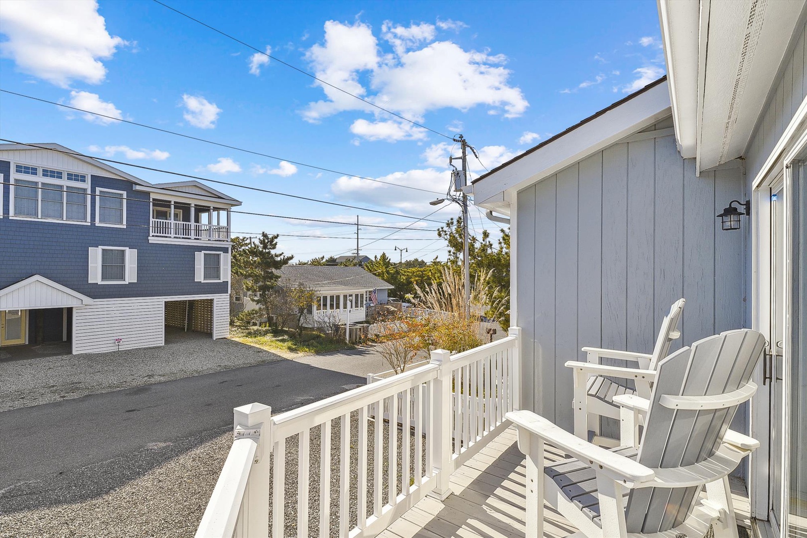 A peaceful residential street setting frames this coastal neighborhood property, with comfortable seating for arrival and departure moments.