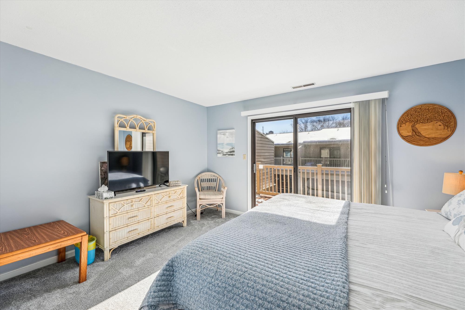 Wake up to peaceful views from your private balcony. This serene bedroom offers plush bedding, a flat-screen TV, and soft coastal-inspired décor for ultimate relaxation.