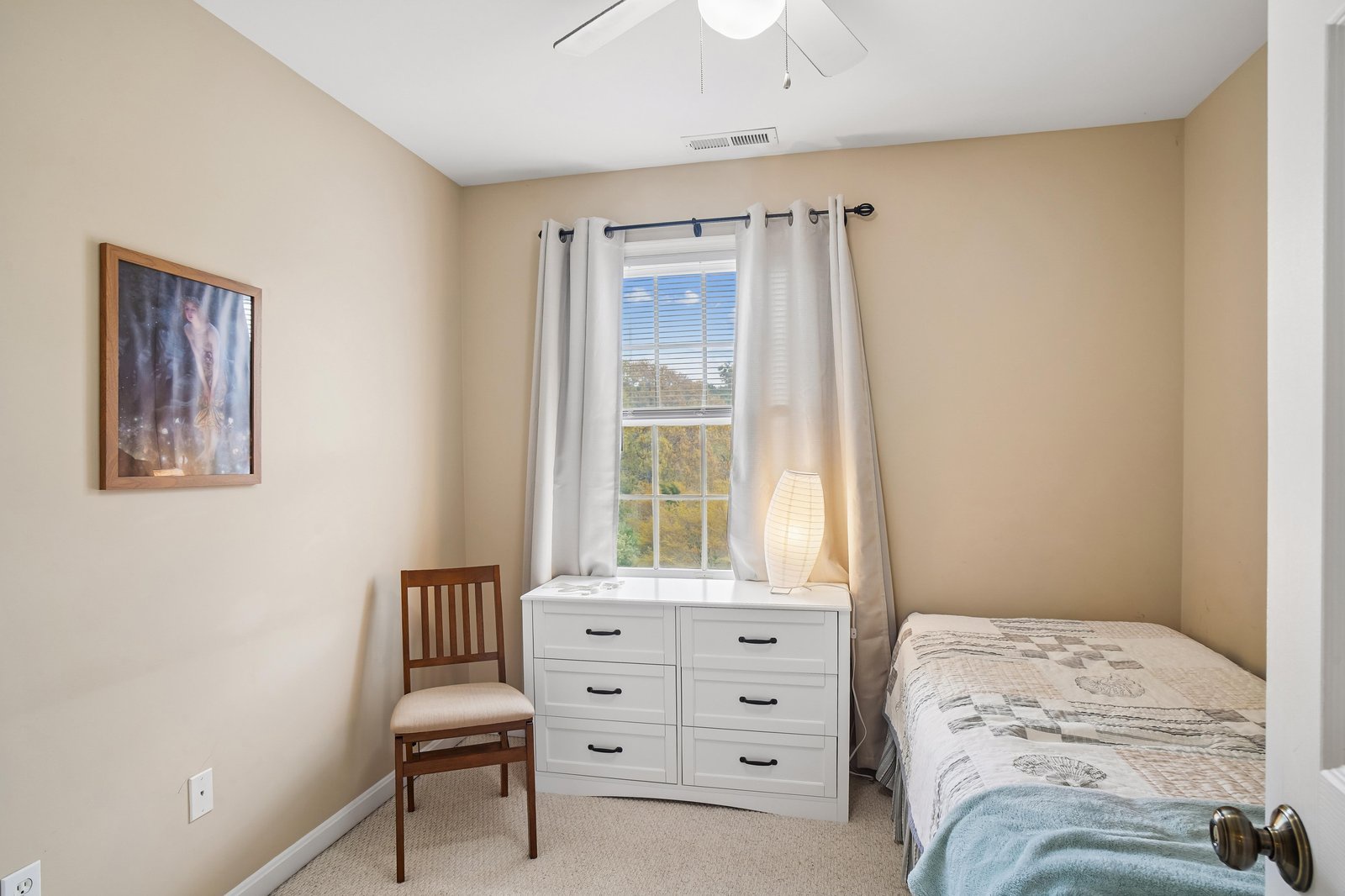Your restful guest bedroom features a cozy bed, dresser, and natural light streaming through the window. A peaceful space to unwind and recharge during your stay.