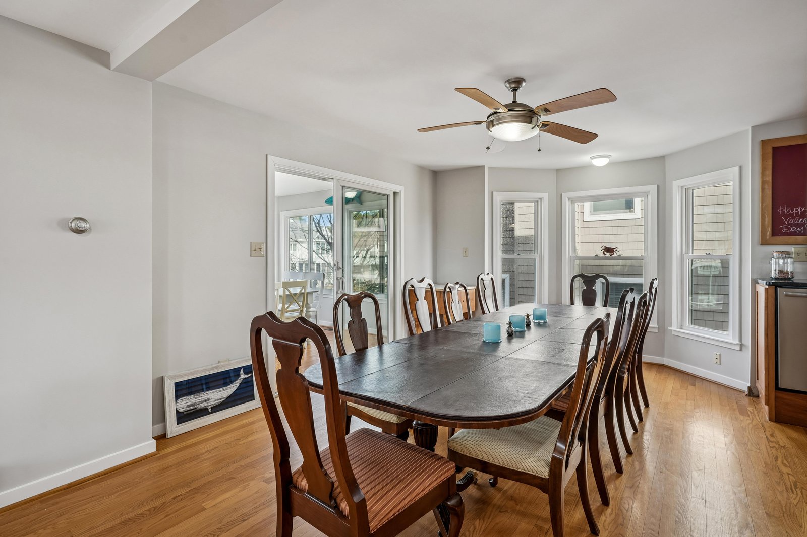 Gather around this spacious dining table with seating for ten, where natural light pours through multiple windows to create a welcoming space for your group's meals and conversations.