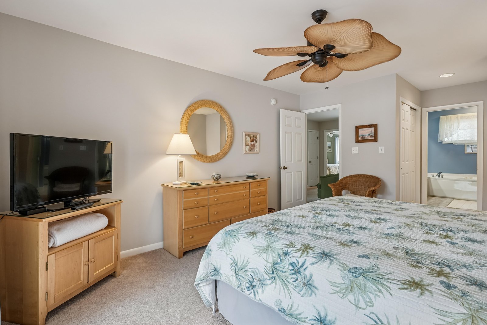 Relax in this coastal-inspired bedroom, where natural wood touches and tropical breezes from the ceiling fan create your tranquil escape. Your private ensuite awaits just beyond.