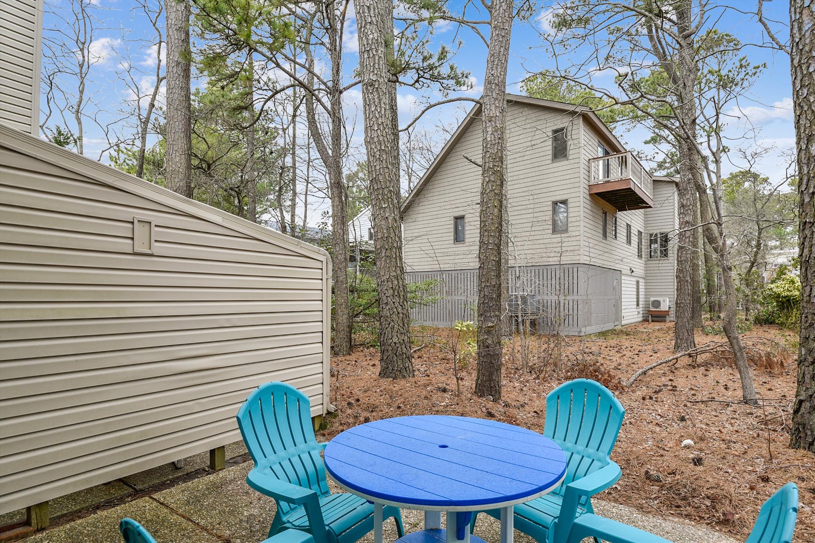 A peaceful, wooded retreat nestled among tall pines—your private escape with a welcoming outdoor dining spot awaits.