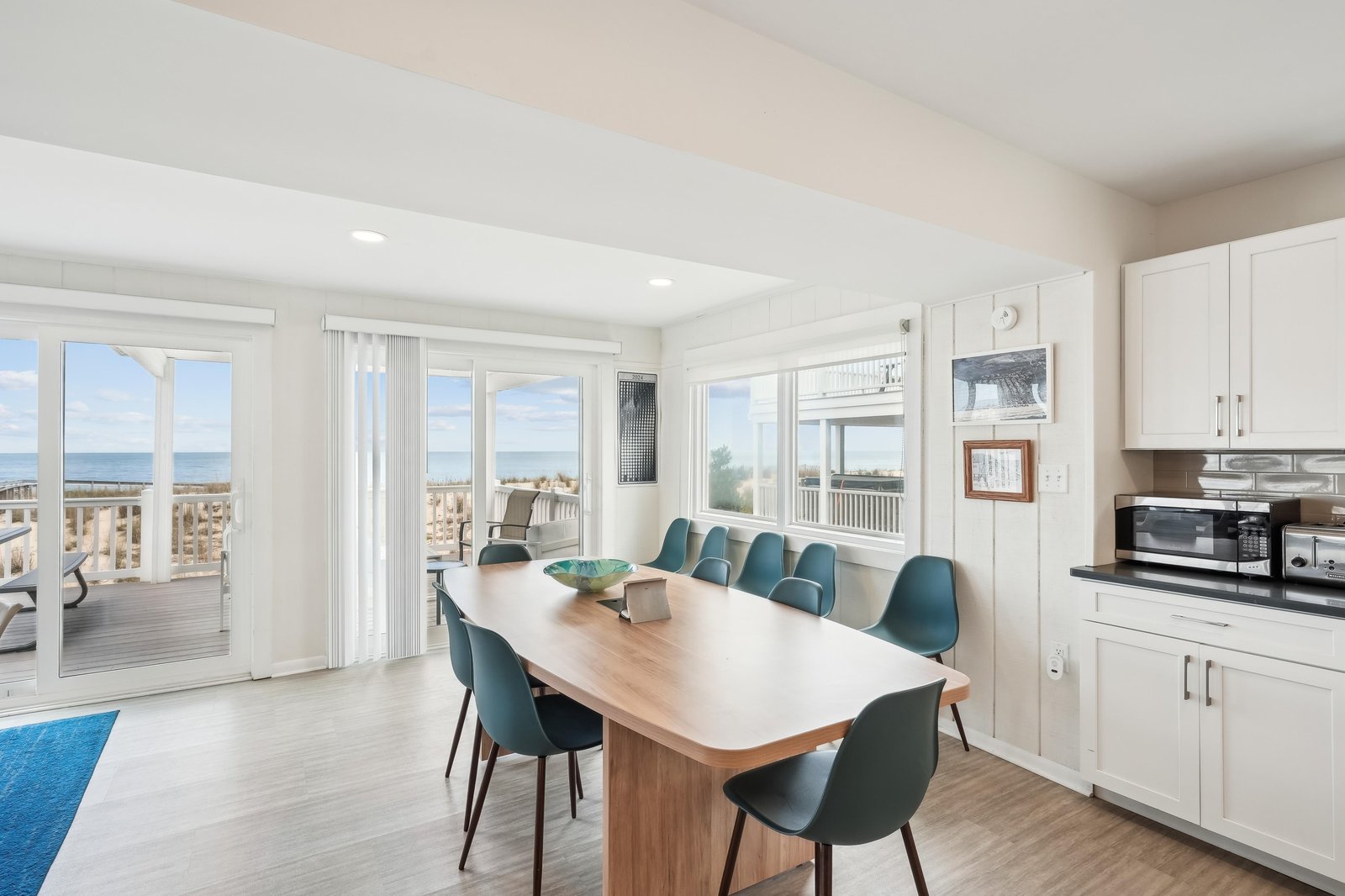 Gather around the dining table with ocean breezes and coastal views framing every meal. Sunlight pours through the windows, connecting you to the beach just beyond your deck.