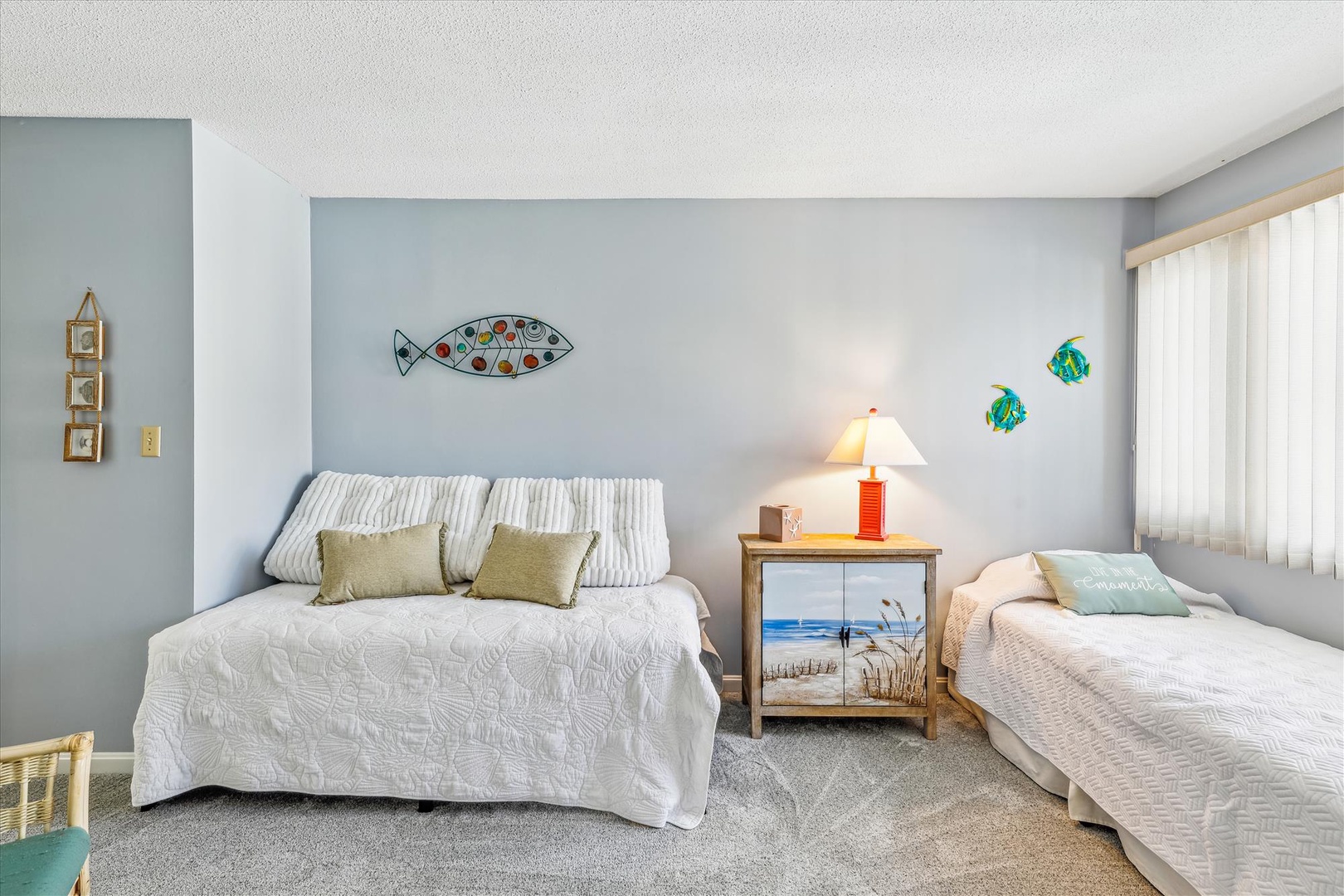 Drift off to sleep in this coastal-themed bedroom, where soft blues and playful fish art create a calming retreat. Your comfortable beds and beachy touches make this the perfect sanctuary.