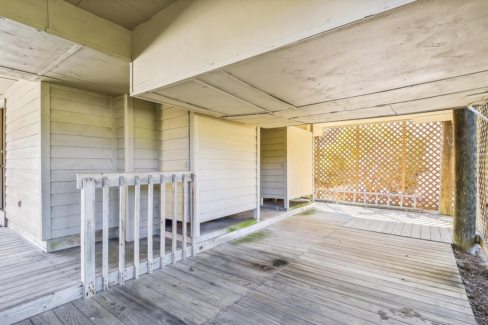 This covered outdoor deck offers a private space for outdoor relaxation, with wooden flooring, lattice privacy screens, and protection from the elements while you enjoy fresh air.
