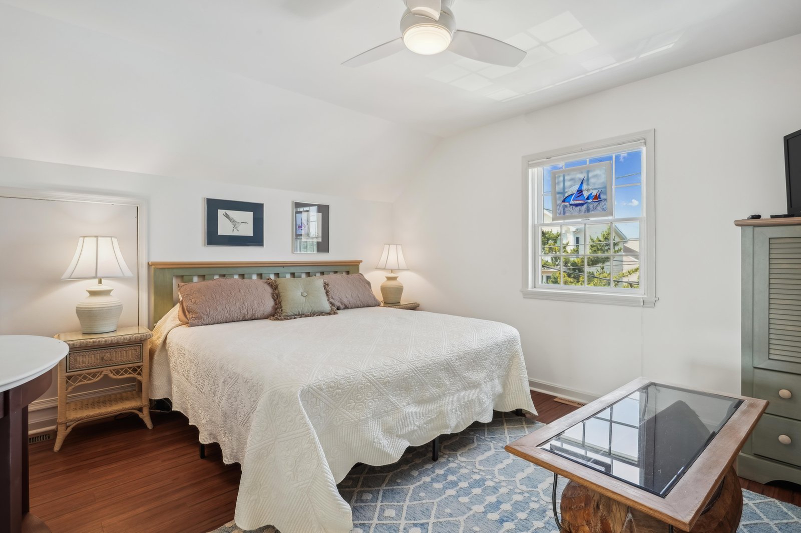 Sink into coastal comfort in your serene bedroom, where natural light pours through the window and tropical breezes keep things cool overhead. Wake up refreshed and ready to explore everything nearby.