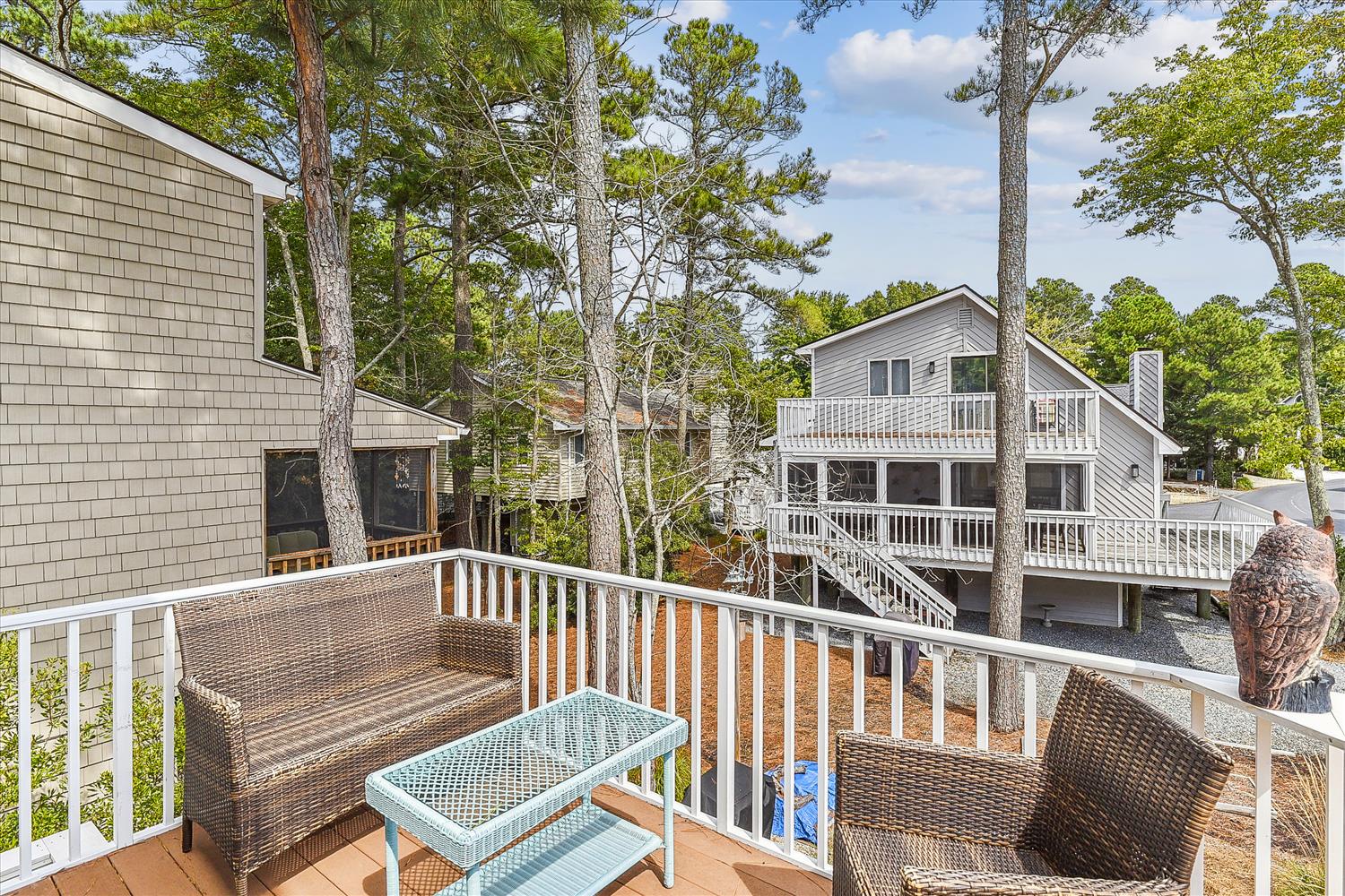 A peaceful wooded neighborhood surrounds the property, featuring vacation homes nestled among tall pines and mature trees. This private rental community offers a serene setting for your getaway.