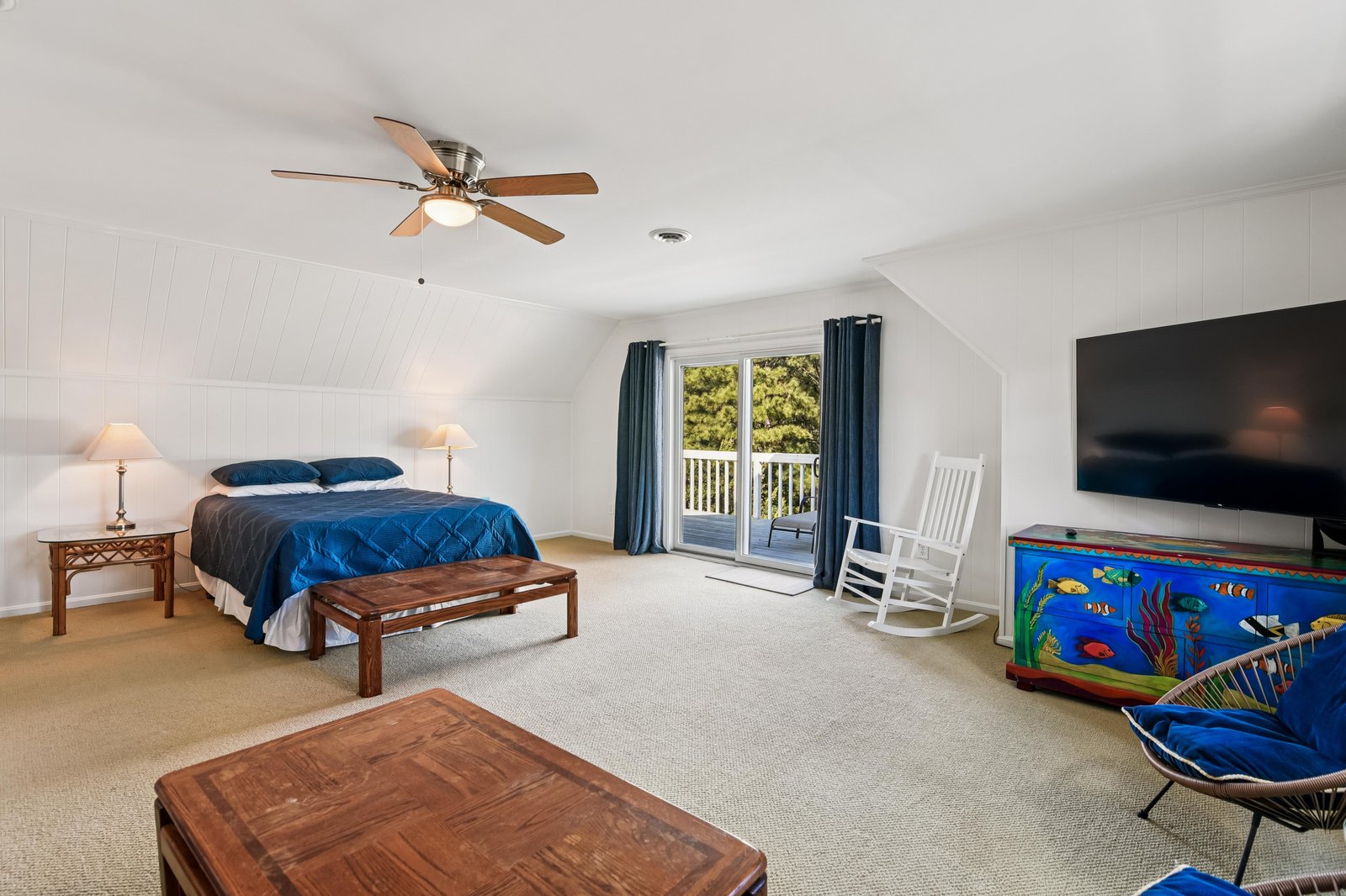 Relax in your spacious bedroom with vaulted ceilings, a comfy king bed, rocking chair, and balcony access. Watch TV or simply unwind in this peaceful retreat.
