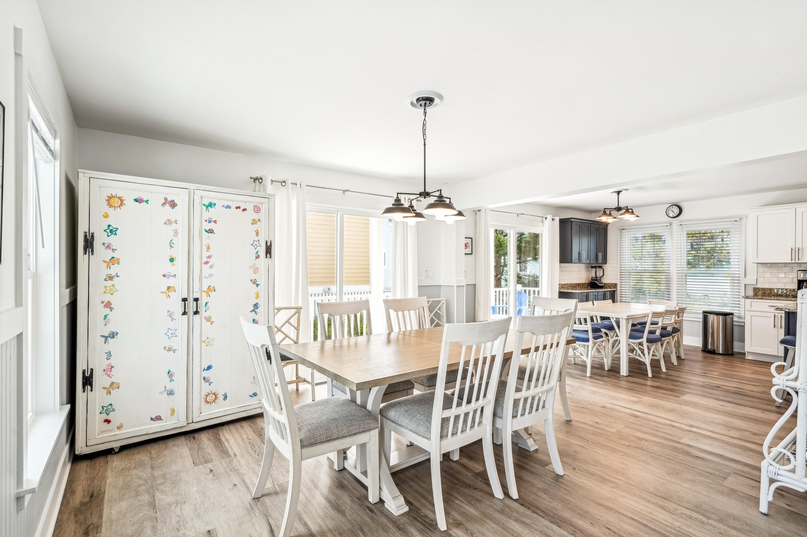 Gather around the spacious dining table in this bright, open-concept space where your group can share meals and make memories together. Natural light floods the room through large windows while the adjoining kitchen makes serving easy.
