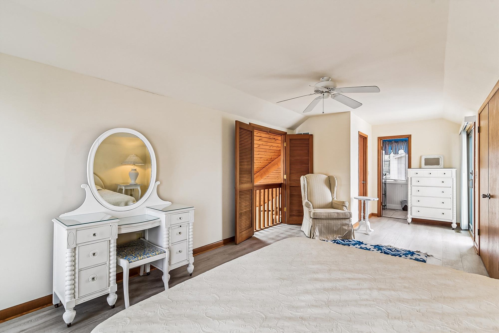 Step into your peaceful retreat, where a vaulted ceiling creates an airy atmosphere and a gentle ceiling fan keeps you comfortable. Your elegant vanity awaits—perfect for getting ready each morning.