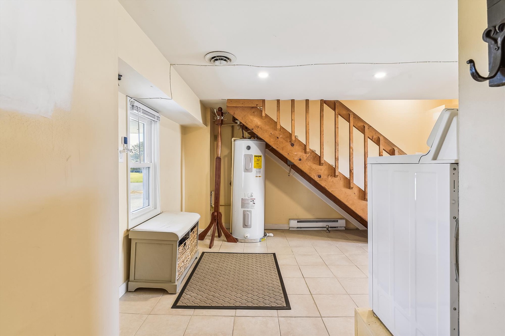 Step into your private entryway, where warm tile floors and natural light welcome you. A cozy bench invites you to settle in as you take in the open, bright space that feels like home from the moment you arrive.