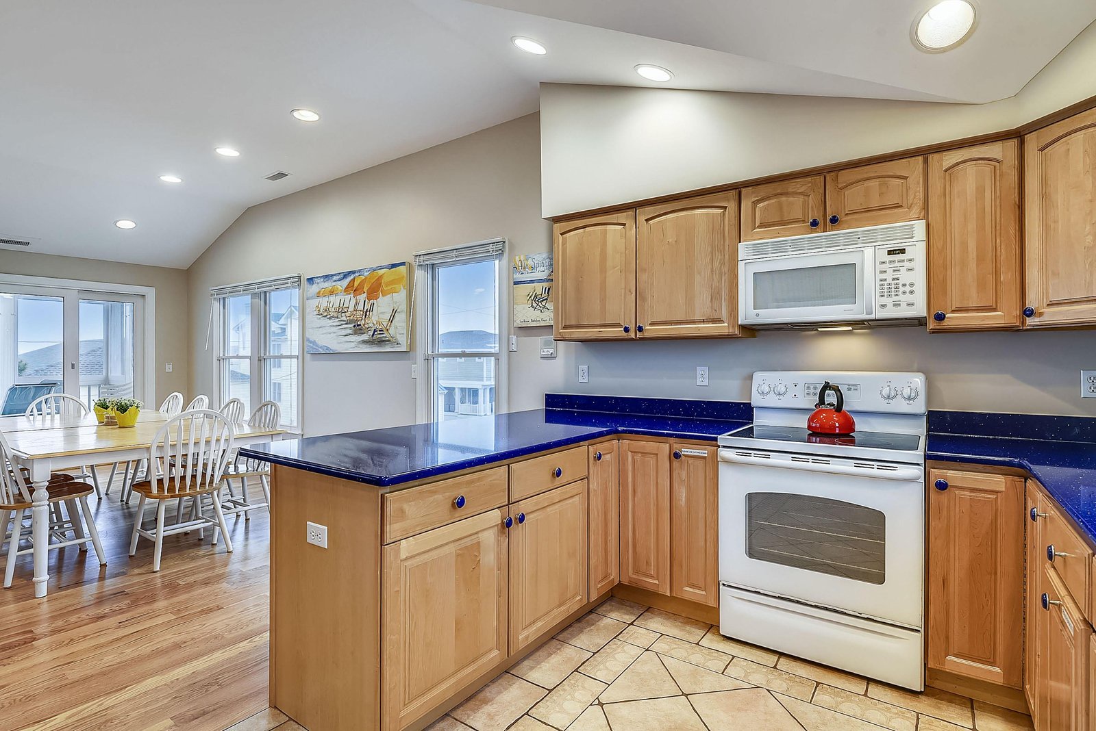 Gather with loved ones in your spacious kitchen featuring rich wooden cabinetry, gleaming blue countertops, and views of the surrounding area. Everything you need to prepare delicious meals together.