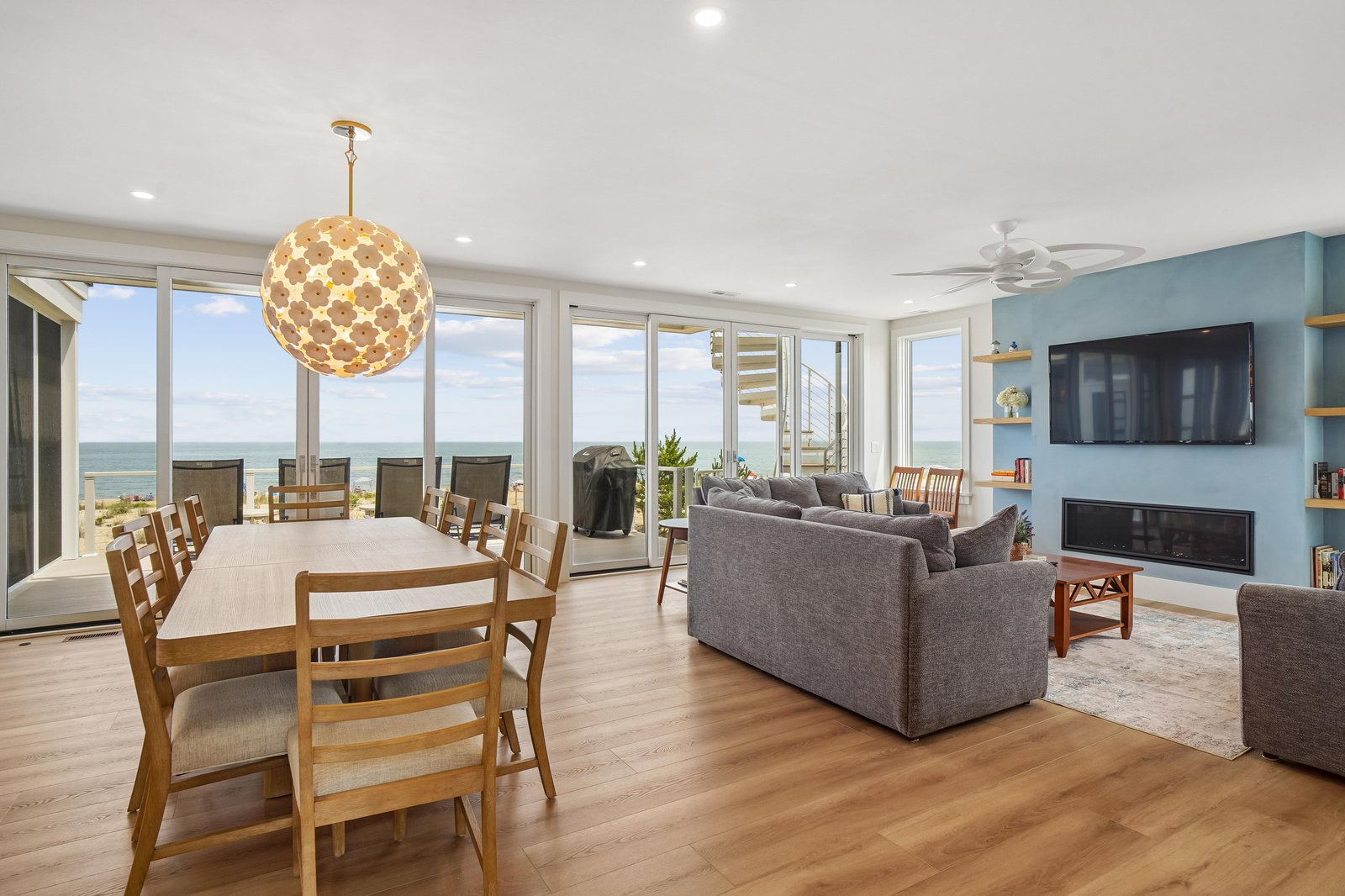 Sunlight streams through floor-to-ceiling windows, framing your ocean views as you gather around the dining table or sink into plush sofas. The open layout invites you to relax, entertain, and savor every coastal moment.