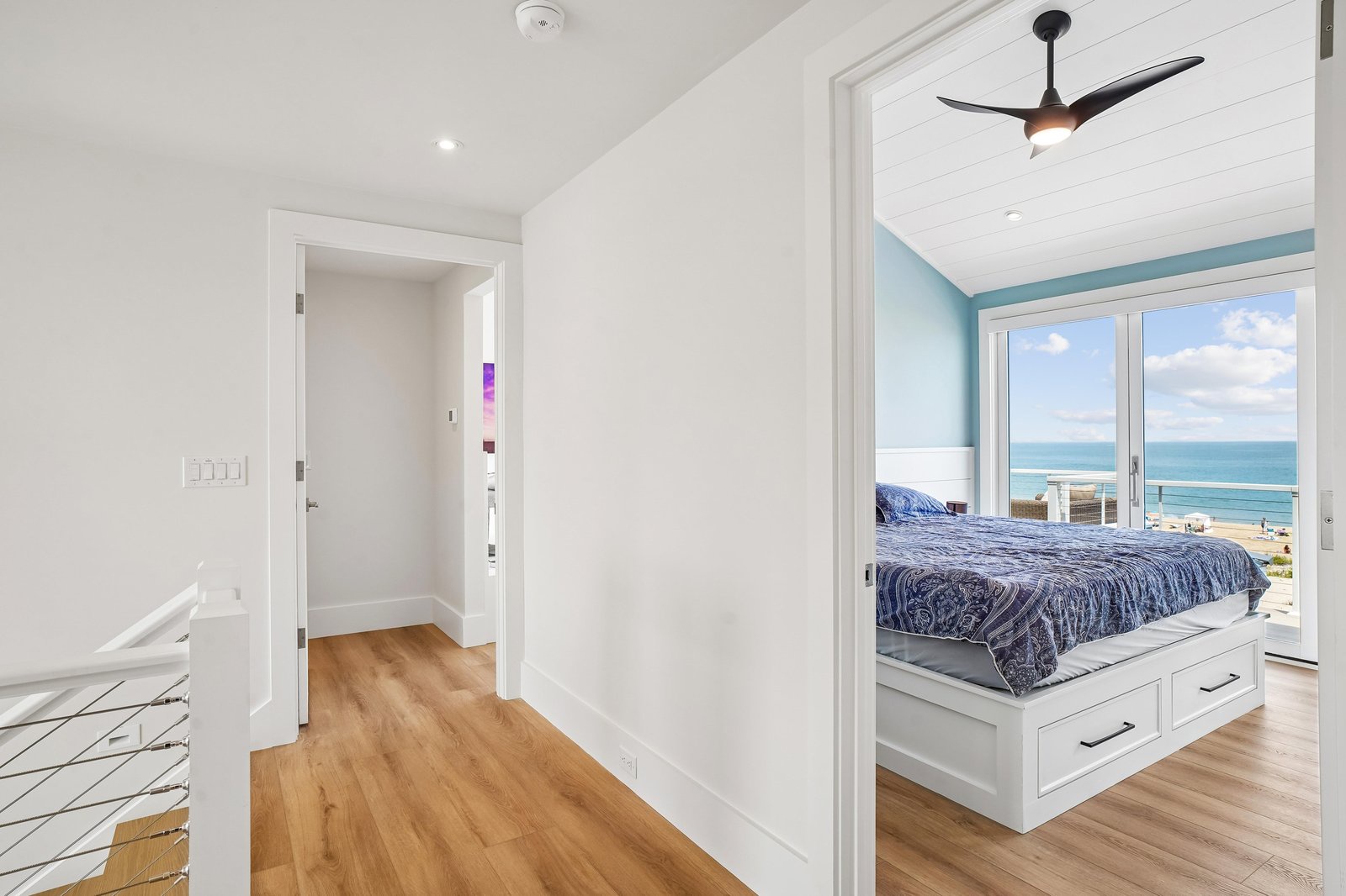 Step into your serene coastal bedroom, where floor-to-ceiling windows frame stunning ocean views. Wake up to the sound of waves and drift off under soft ceiling fan breezes.