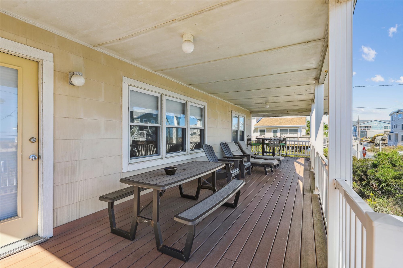Your covered deck offers comfortable seating and lounging space, perfect for outdoor meals or relaxing with ocean breezes and neighborhood views.