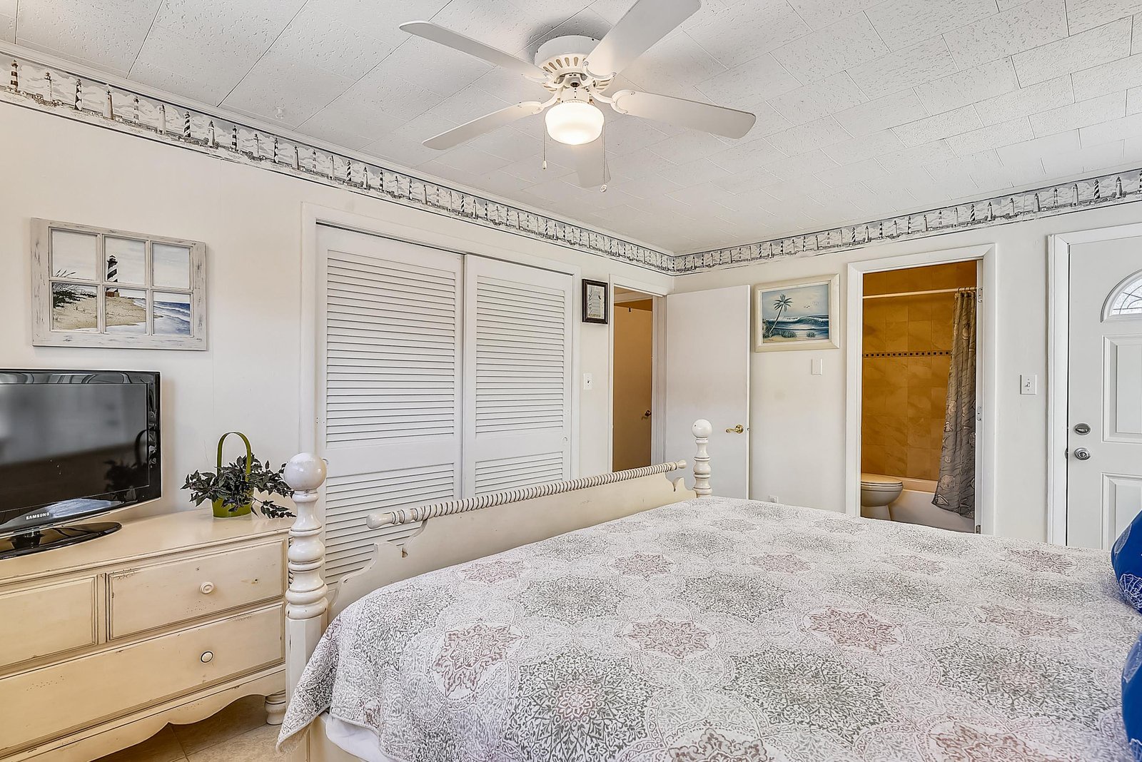 Unwind in your bright, coastal-inspired bedroom with a plush queen bed, your own TV, and gentle ceiling fan. Just steps away, your private bathroom awaits for ultimate convenience.