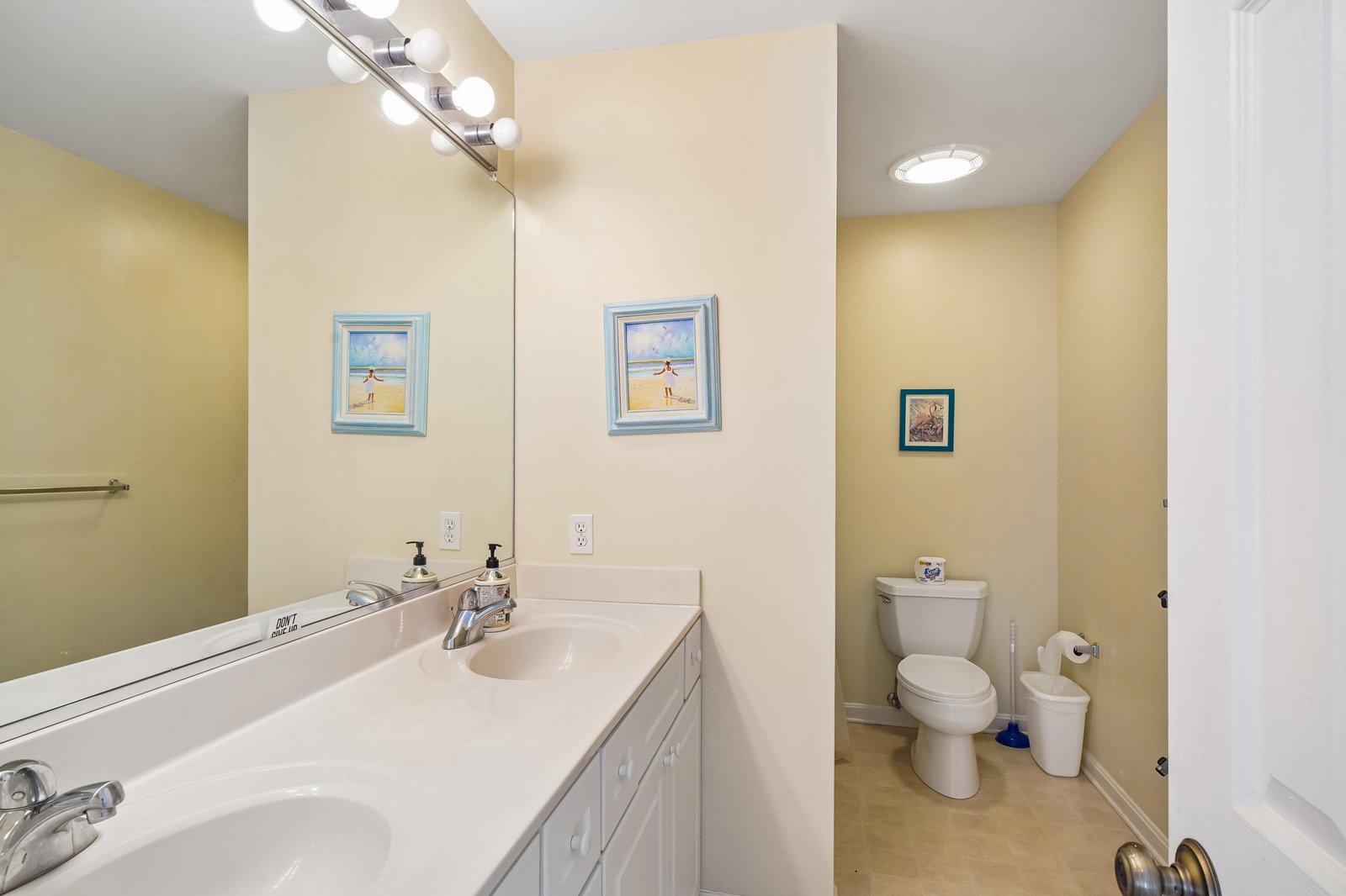 Bright bathroom with dual vanities, spacious countertop, and soft lighting creating a fresh, welcoming space for your morning routine or evening unwind.