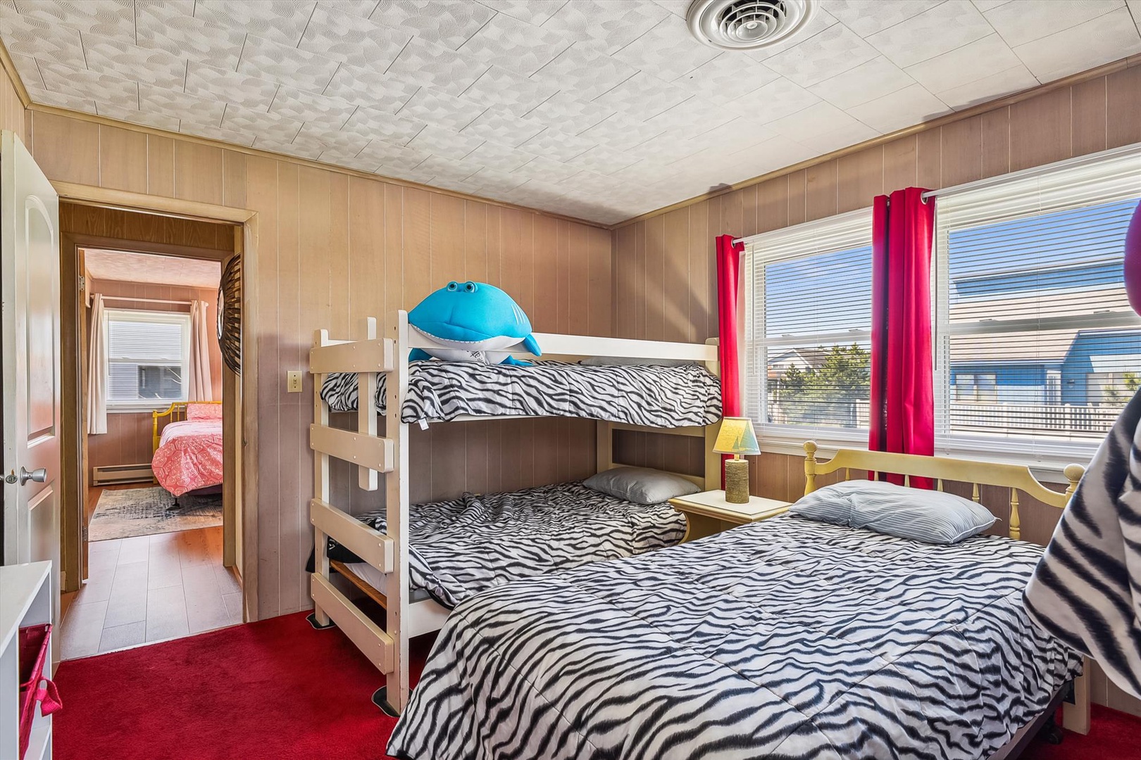 Cheerful room with zebra-print bedding, a bunk bed, and playful pops of color—perfect for families looking to rest together after a fun-filled day.