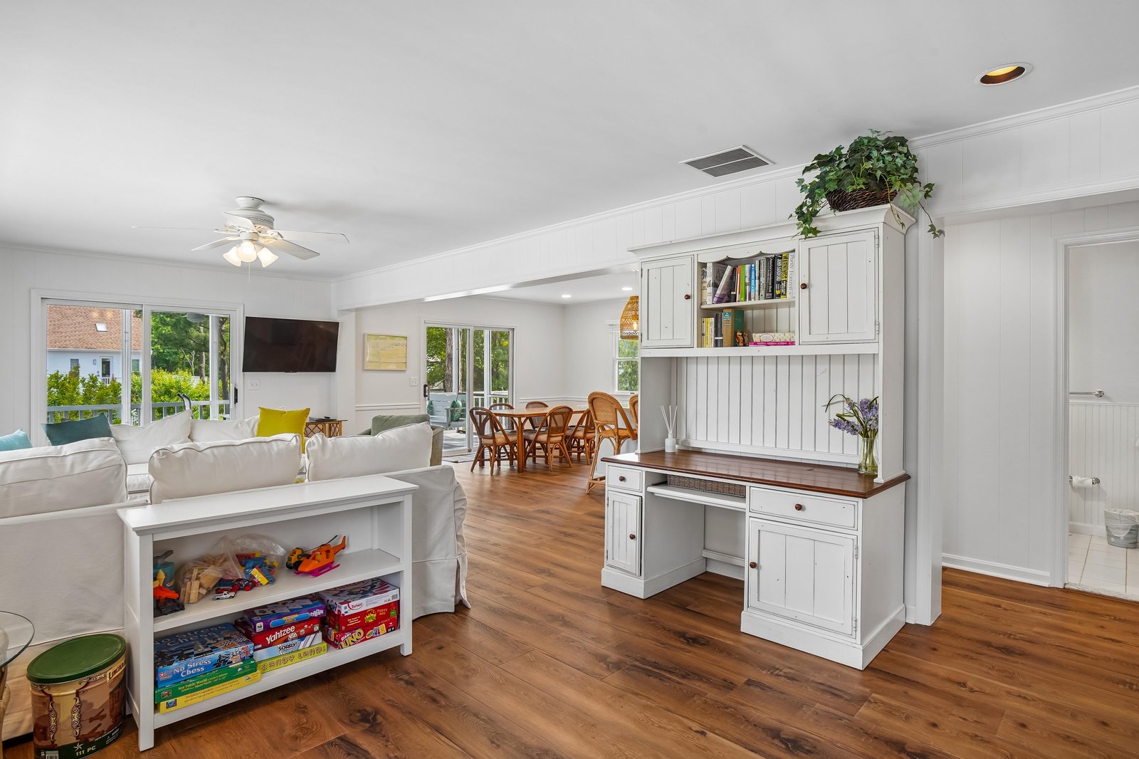 Step into your bright, airy living space where coastal charm meets comfort. Gleaming hardwood floors and white beamed ceilings create a welcoming atmosphere perfect for relaxing after a day of adventures.
