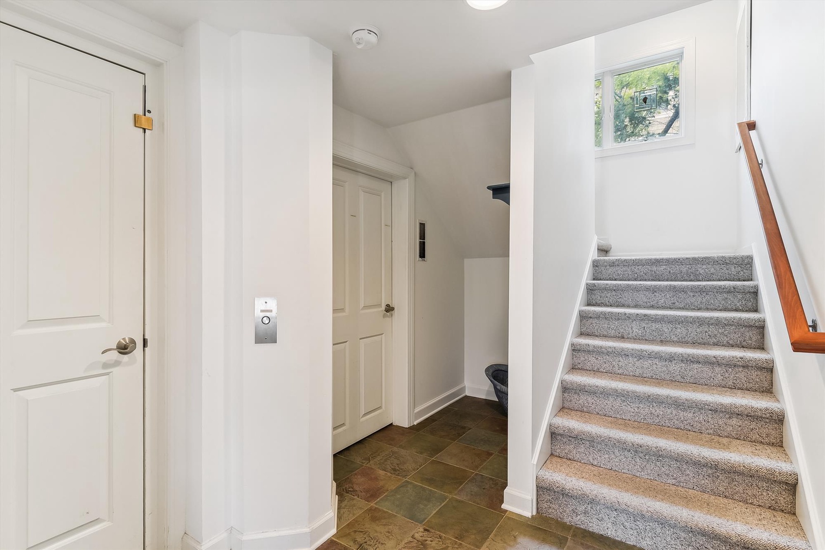 Bright, welcoming entryway with natural light guiding you upstairs to your comfortable retreat. Clean, modern space ready for your arrival.