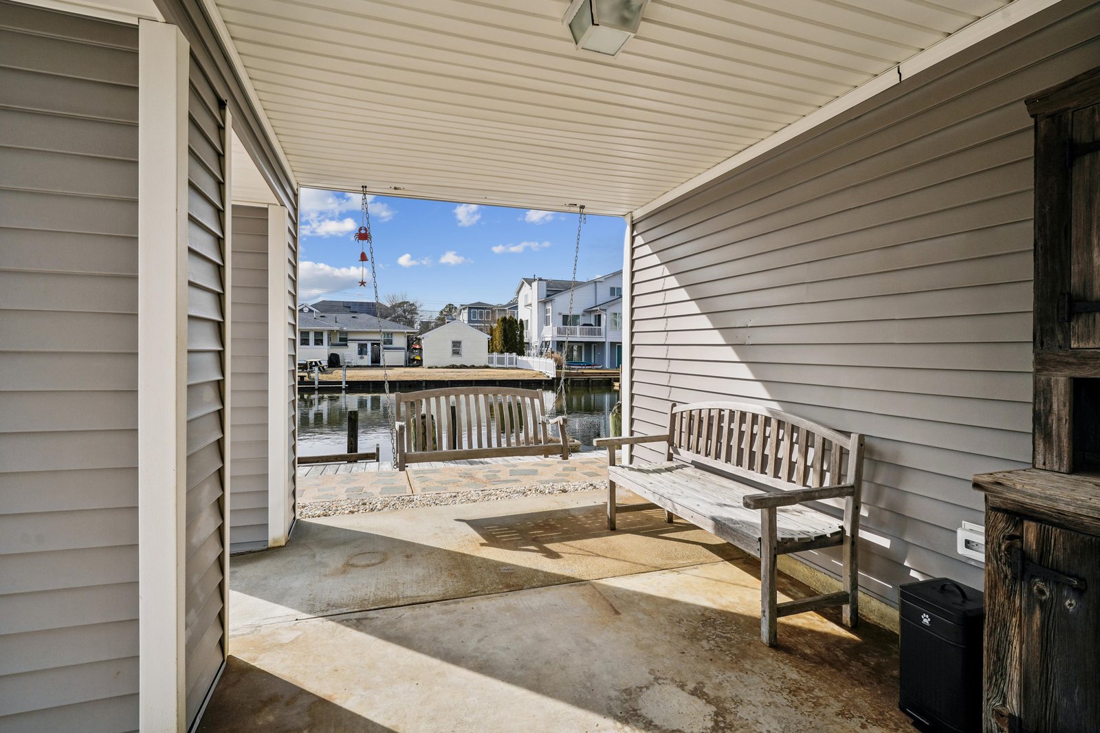 This covered waterfront patio offers your peaceful spot to watch boats drift by, with a weathered bench perfect for morning coffee and a private dock just steps away.