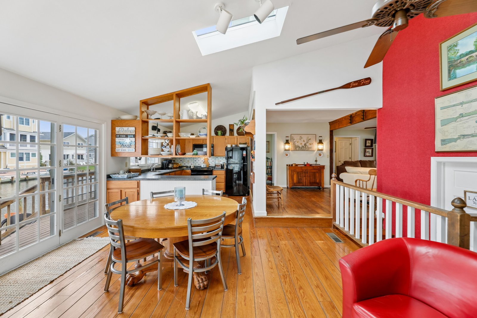 Sunlight pours through the skylight as you gather at the dining table with water views stretching just beyond the glass doors, your ideal spot for morning coffee or lively evening meals.