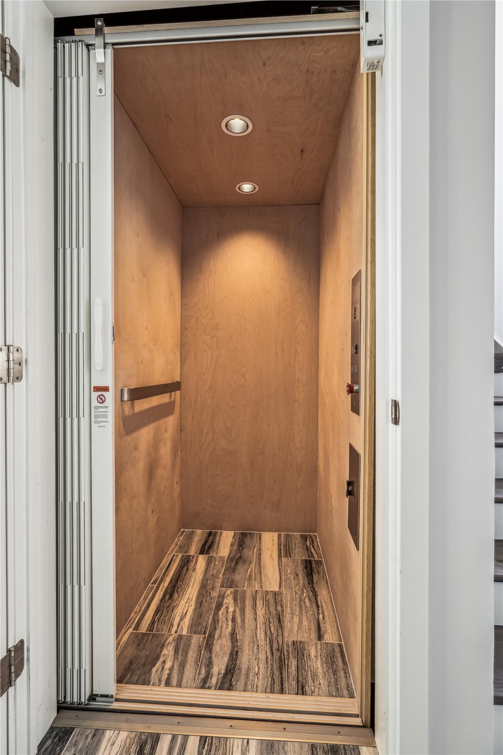Step into your private elevator—beautifully finished with warm wood tones and ambient lighting, ready to whisk you effortlessly to your retreat.