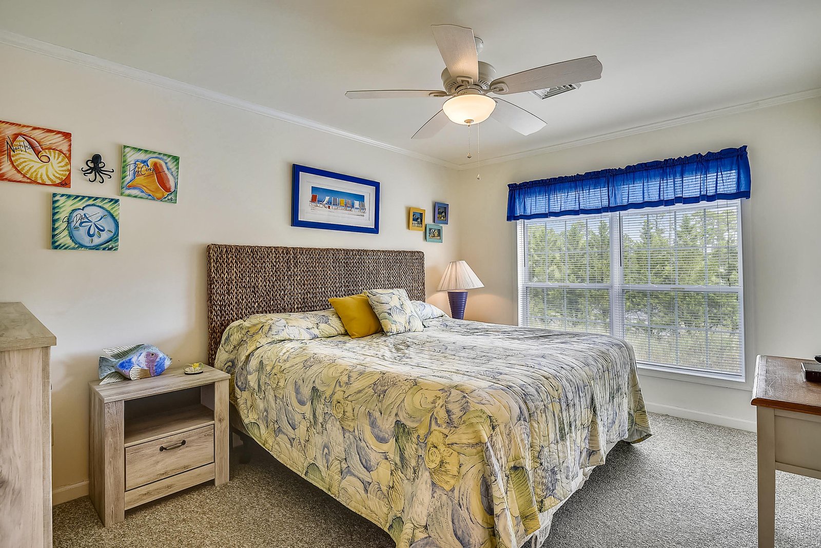 Drift off in your tranquil coastal-themed bedroom, where cheerful colors and natural light create a peaceful retreat after your day of adventure.