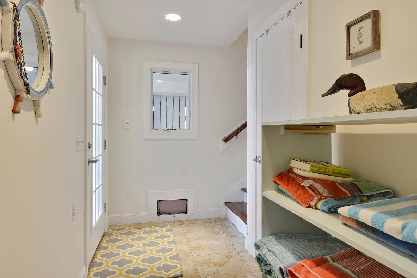 Step inside to a bright, welcoming entryway where natural light filters through. Fresh towels, nautical touches, and coastal charm create your perfect beach escape the moment you arrive.