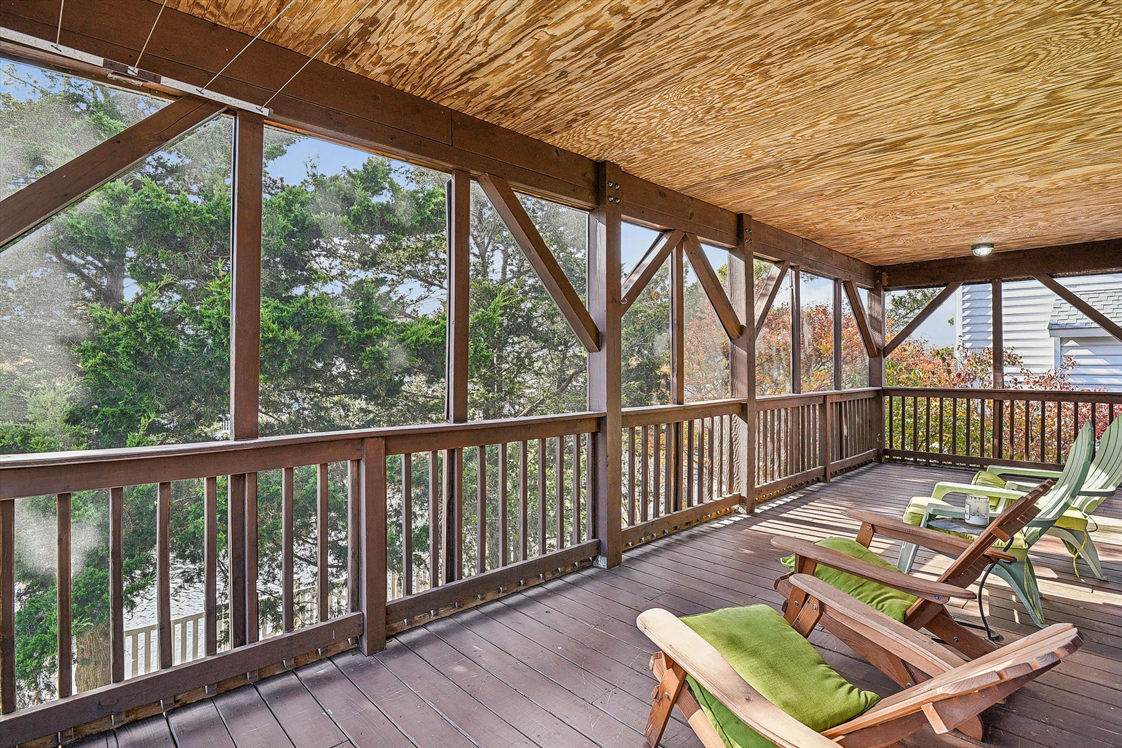 Relax in your screened porch overlooking leafy trees and autumn foliage. Lounge chairs and natural wood details create a peaceful retreat to unwind and reconnect.