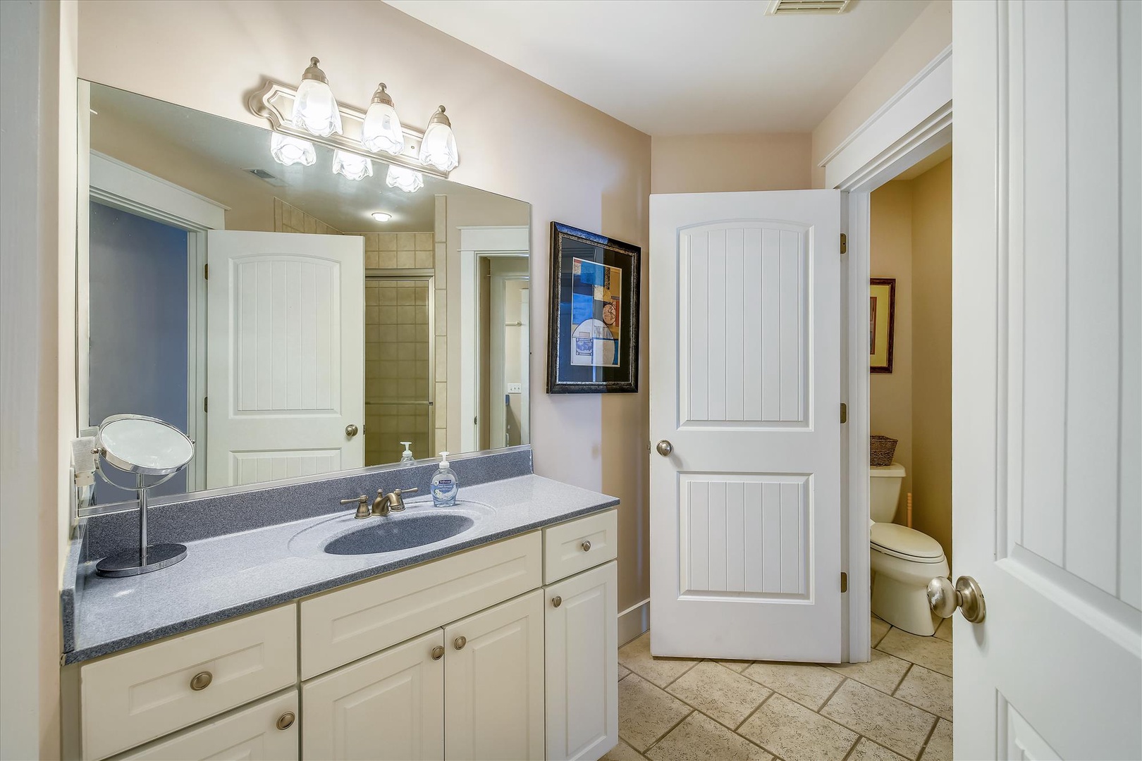 Your private bathroom features a granite vanity with soft lighting, a spacious mirror, and crisp white cabinetry—perfect for refreshing after a day of adventure.