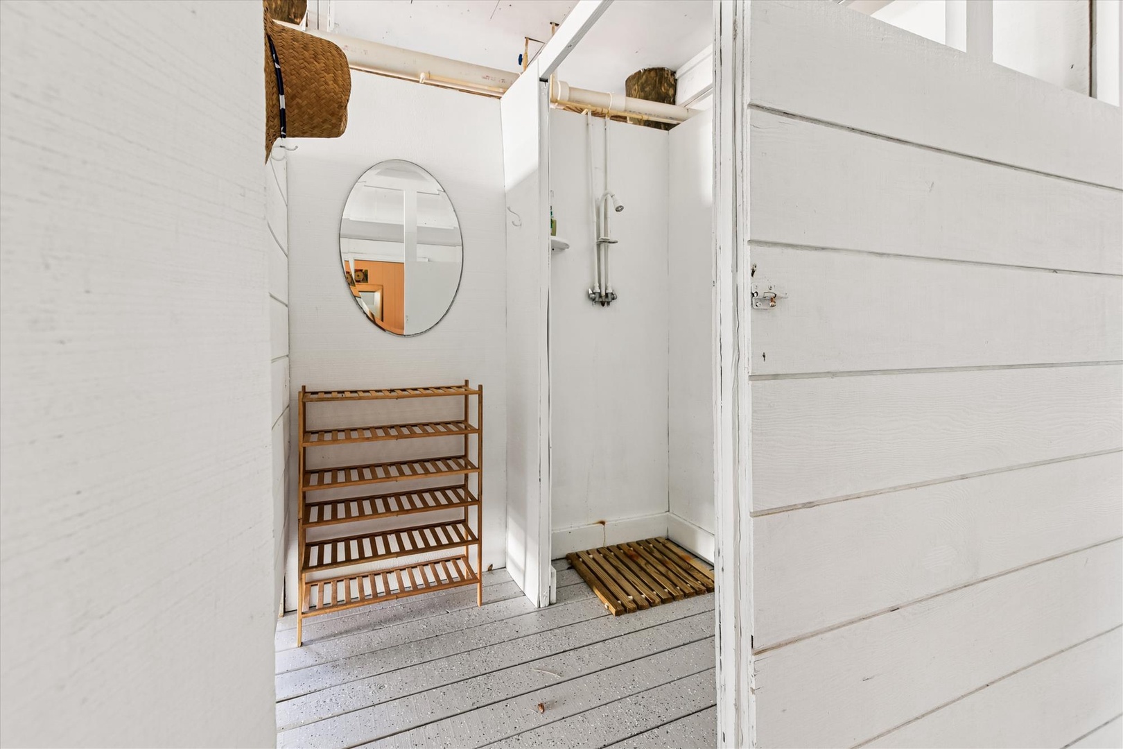 Step into your private outdoor shower where coastal charm meets modern comfort with bamboo accents and nautical touches.