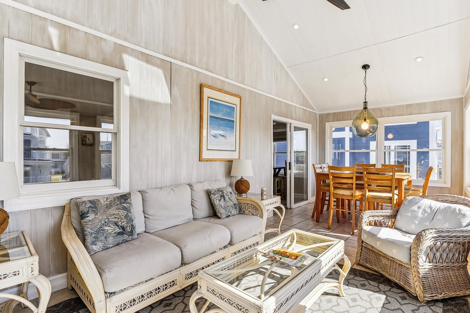 Step into a bright coastal-inspired living space where whitewashed walls and vaulted ceilings create an airy retreat. Your dining table awaits near the balcony, perfect for morning coffee or gathering with loved ones.