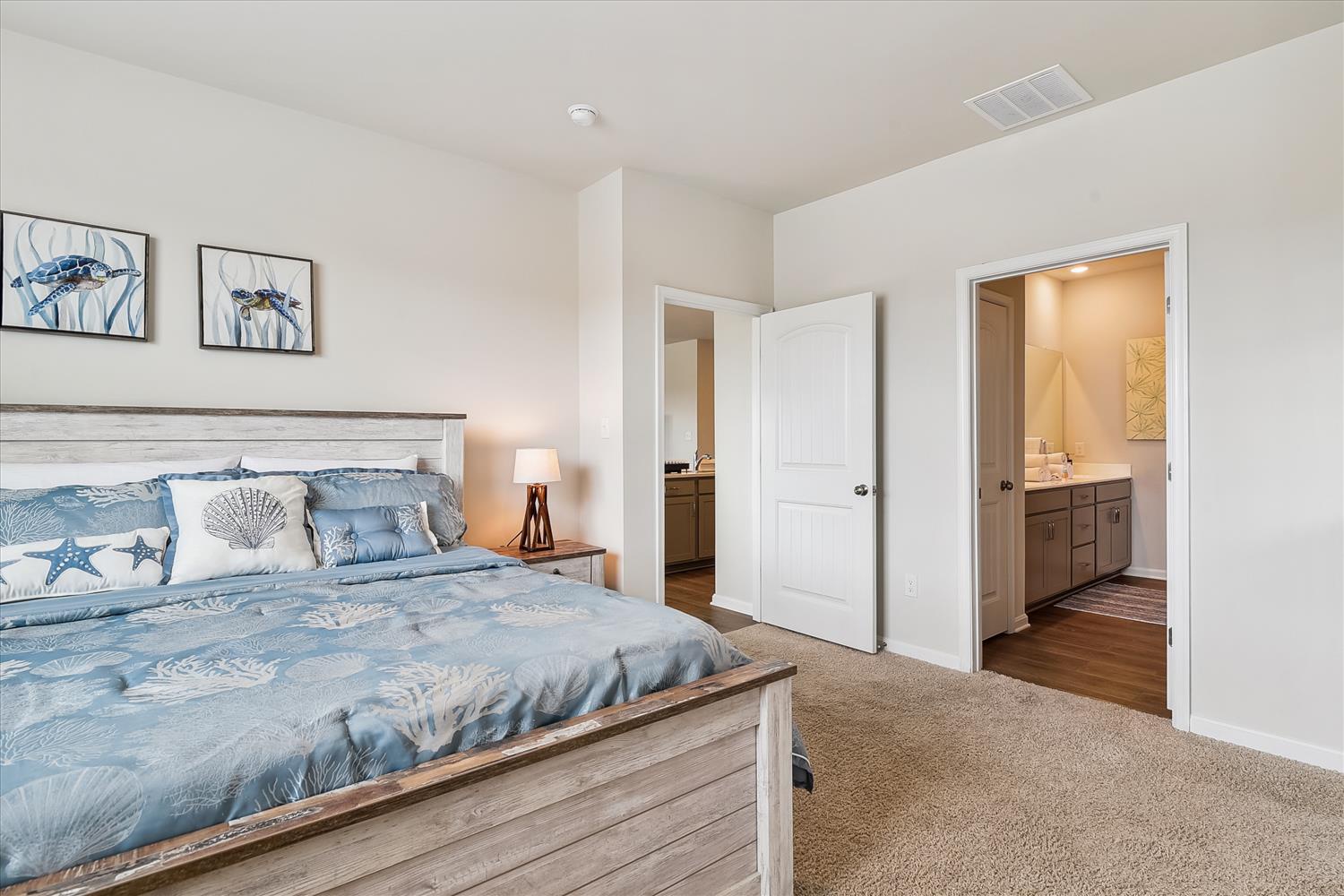 Drift off in your serene coastal retreat with ocean-themed bedding and convenient en-suite bathroom access for ultimate comfort.