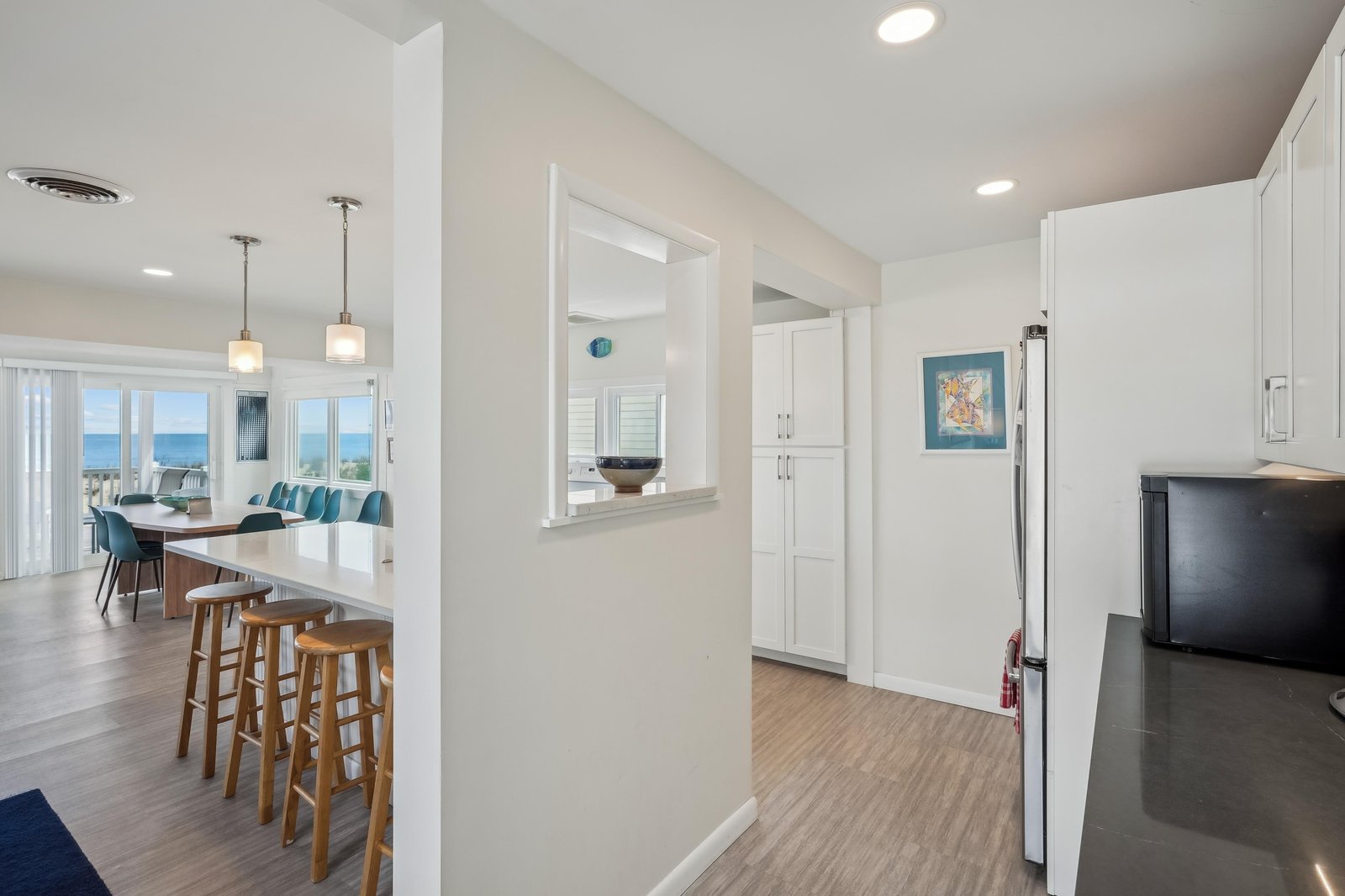 Step into a bright, open layout where the kitchen flows effortlessly into your dining and living areas. Natural light streams through the windows, revealing stunning ocean views beyond—your backdrop for morning coffee and evening relaxation.