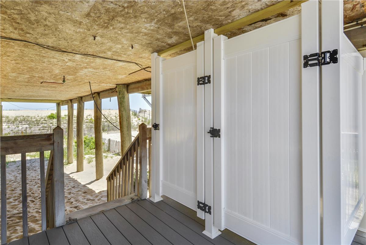Covered beachfront deck with storage lockers provides direct access to the sand and coastal scenery just steps from your door.