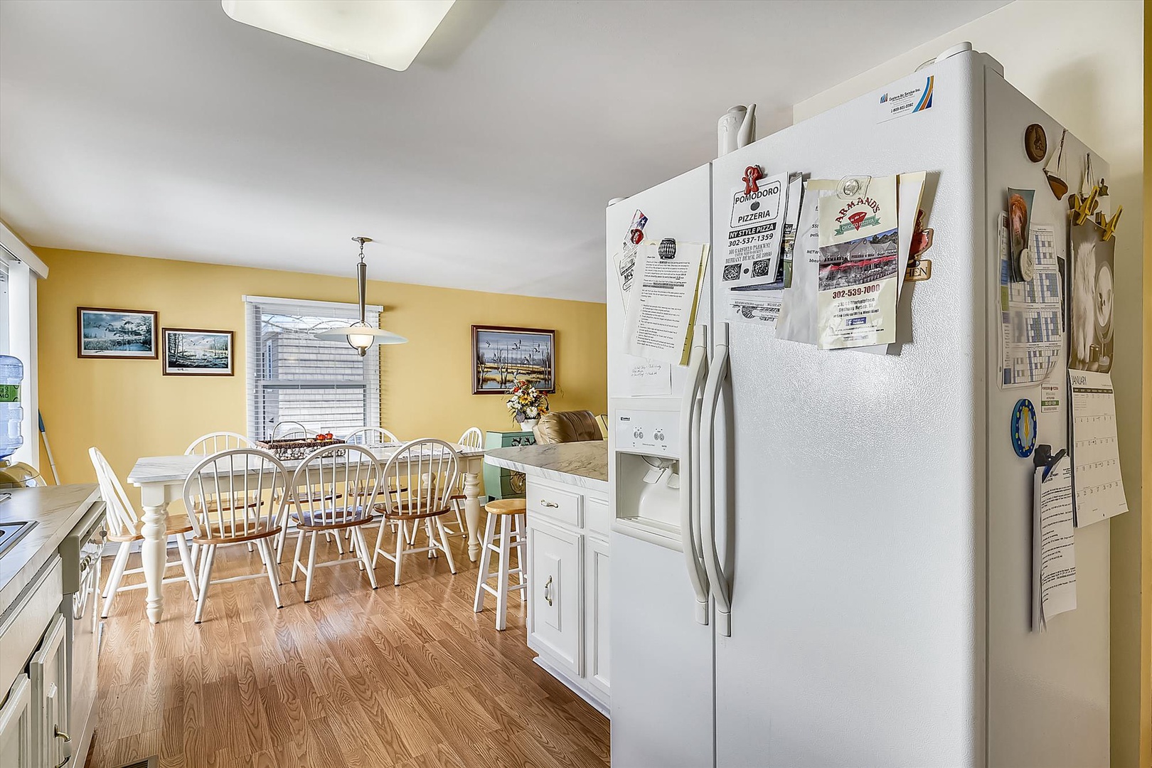 Step into your bright, homey kitchen and dining space with warm yellow walls, comfy seating for six, and everything ready for memorable meals together.