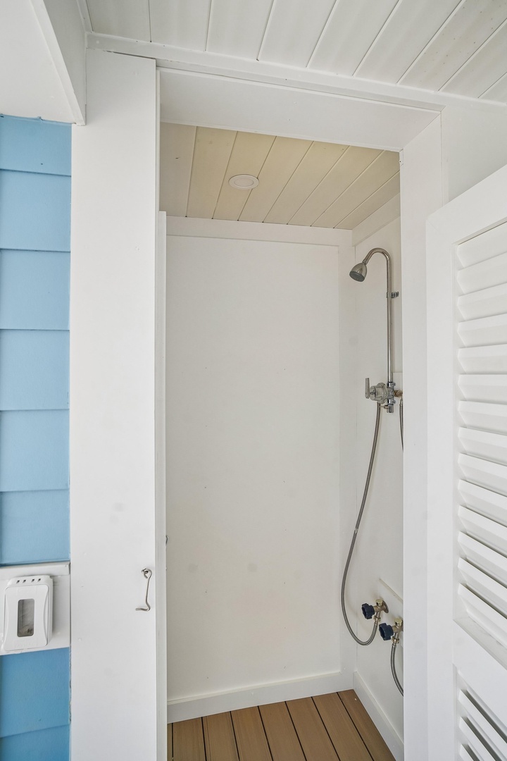 Rinse off after beach days in your private outdoor shower with warm wood floors and a coastal vibe.