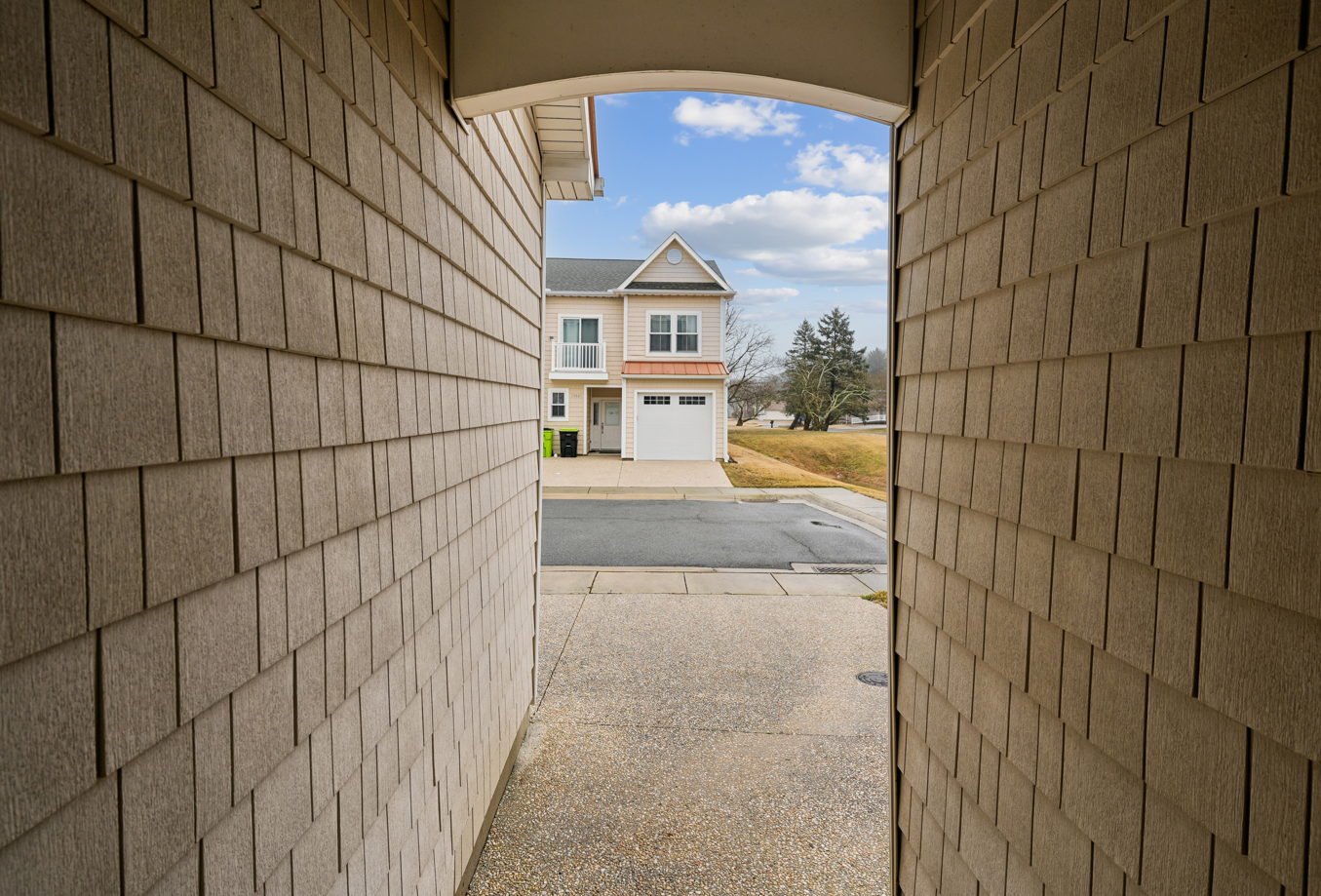 Modern residential neighborhood with well-maintained homes and paved parking areas visible from the property entrance.