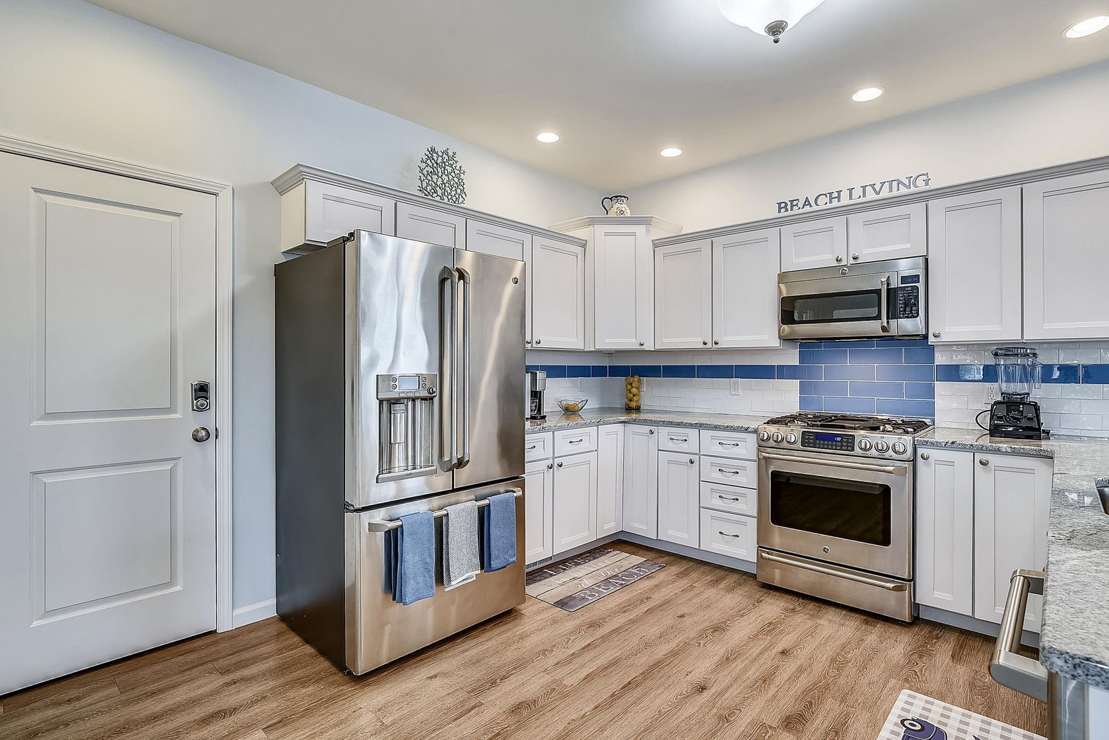 Step into your coastal kitchen, where crisp white cabinetry and ocean-blue accents create a breezy, beach-inspired vibe. Stainless steel appliances and granite counters make meal prep effortless.